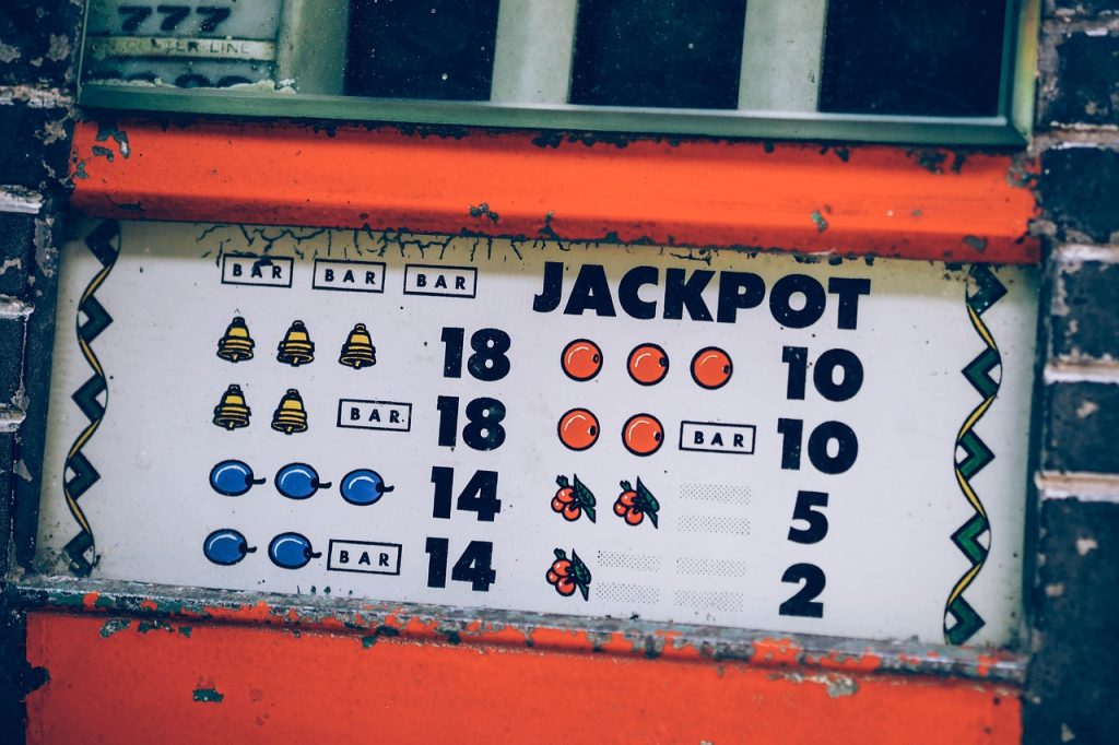 Kolikkopeli, jonka voittoyhdistelmät kuvaavat symbolisesti pelihuumoria ja kieltä pelikulttuurissa.
